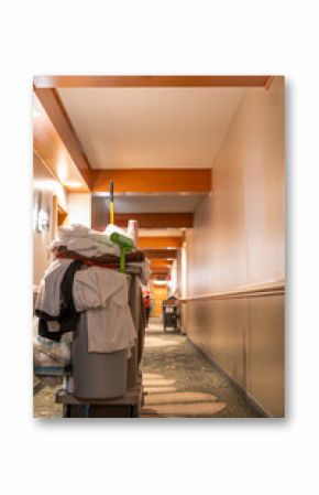 Hotel hallway with room service cleaning cart with supplies.