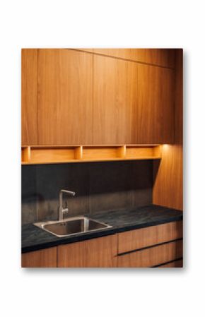 Water faucet and metallic sink in modern sleek kitchen with led strip light