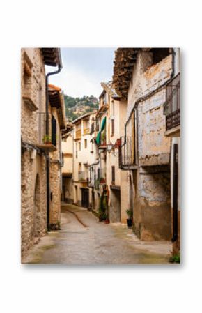 Picturesque alley with old stone houses in the medieval village of Rafales, Teruel, Spain.