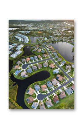 Upscale suburban homes at sunset with large backyards and green grassy lawns. Private residential houses in rural suburban sprawl area in Sarasota, Florida