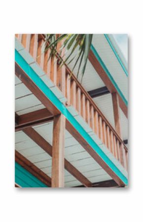 Wooden balcony with turquoise trim under palm leaves in Belize