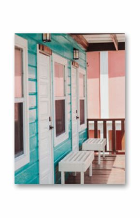 Colorful turquoise and pink guesthouse porch with white benches