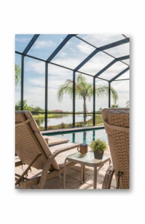 Lounge chair beside blue swimming pool in suburban Florida home with screened enclosure and palm trees.