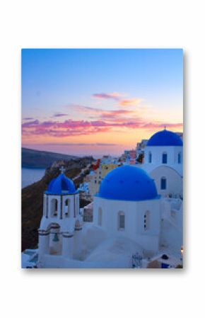 townscape of Oia, traditional greek village of Santorini, with blue domes of churches close up at sunset, Greece