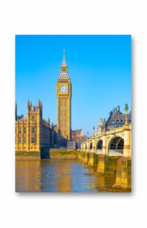Big Ben stands tall against a clear blue sky, reflecting sunlight on the River Thames. The iconic clock tower is surrounded by historic buildings, marking London's rich heritage.