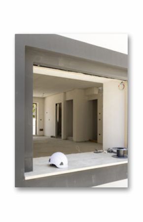 White hard Safety helmet on the window sill in a new house construction site. Protection equipment