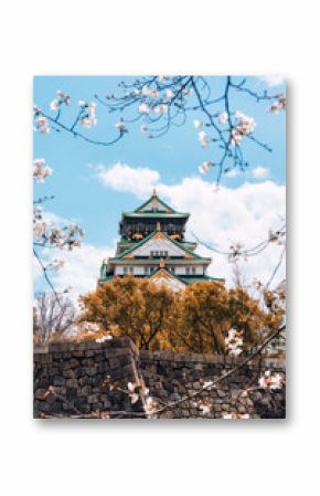 Osaka Castle framed by cherry blossom blooming in Japan