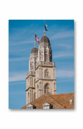 Grossmunster church towers rising above zurich with swiss flags