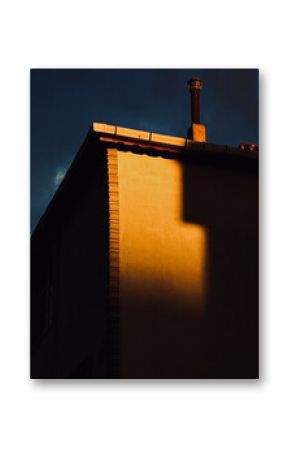 Abstract View of a Building Corner and Chimney Lit by Warm Sunset Light