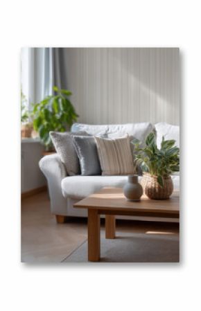 Cozy modern living room with white sofa, decorative pillows, wooden coffee table, indoor plants, and natural sunlight