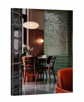 Cafe interior: wooden table and chairs near green tiled wall and glass window. Empty dining room, designed in mid-century modern style with lots of wooden elements, green tiles and glass blocks.