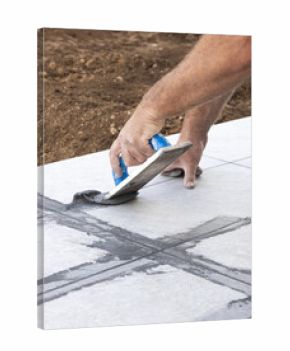 Craftsman filling tile joints with grout using a float, hand closeup, building construction detail