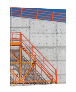 Orange Metal Staircase Against Concrete Wall and Clear Blue Sky