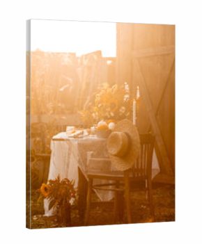 Beautiful fancy fall wedding table decor, countryside style cottage core. Vintage wooden furniture, candlelight, centrepiece with natural sunflowers. Cozy atmosphere, autumn vibes, stylish house decor