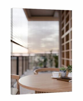Coffee and notebook with pot plants on wooden table at balcony or terrace with blinds and evening sky.