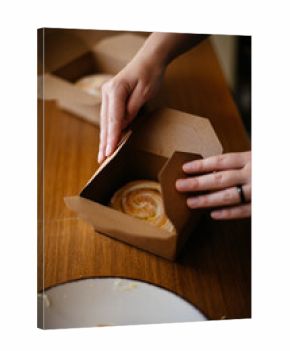 Hands closing bakery box with roll