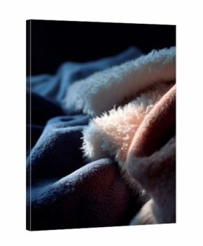 Soft and cozy blankets on a dark surface create a warm atmosphere