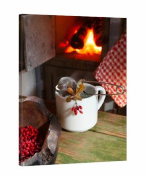 cup of hot barberry tea in front of fire