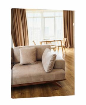 Sofa cushion livingroom hardwood curtains diningtable in a sunlit modern apartment interior, cozy neutral upholstery on wooden floor with minimalist dining area and soft natural light.