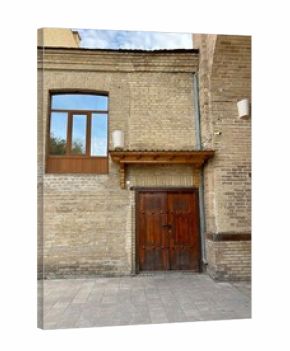 Carved wooden doors, window on historic yellow-brown brick wall facade