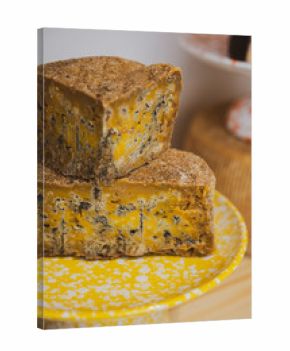 Stacks of yellow, blue cheese on yellow plate