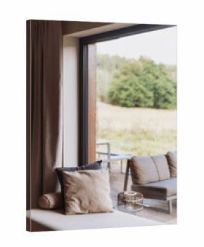 Cozy minimalist living room with large windows overlooking nature