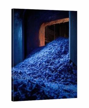Blue shredded plastic strips piled inside a dark industrial tunnel. Concept Industrial Aesthetics, Blue Shredded Plastic, Moody Tunnel Lighting, Textured Abstraction, Urban Decay