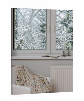 Window view of snowy trees in a cozy room during winter season
