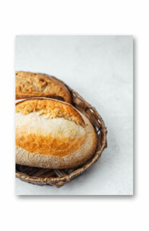 Freshly baked bread loaves in a woven basket on a light surface