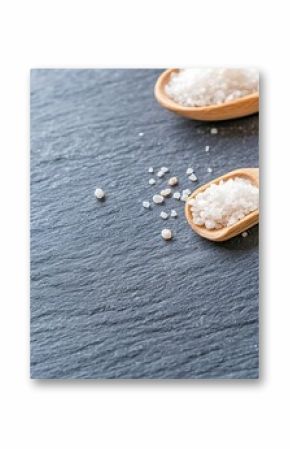 White Sea Salt Crystals in Wooden Spoons on Dark Slate Texture