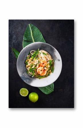 Authentical Asia style ramen noodle soup with prawns and cashew nuts served as top view in a design bowl