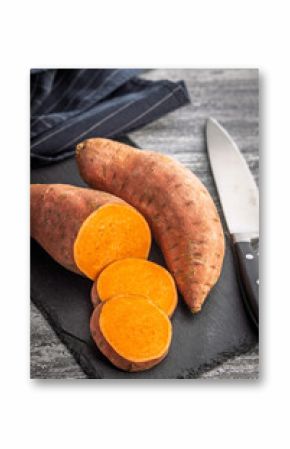 Raw sweet potatoes on kitchen table.