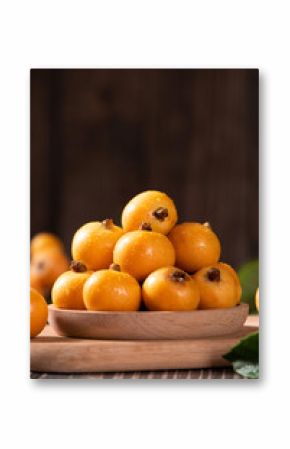 Ripe loquats fruit on wooden table.