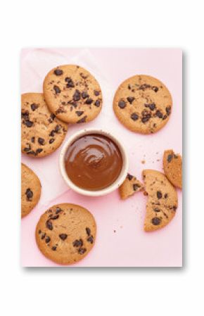 Tasty cookies with chocolate chips and bowl of sauce on pink background