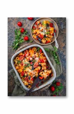 Homemade italian baked cheesy mezze maniche Pasta alla norma with eggplant, olives and tomatos served as top view in stoneware casserole