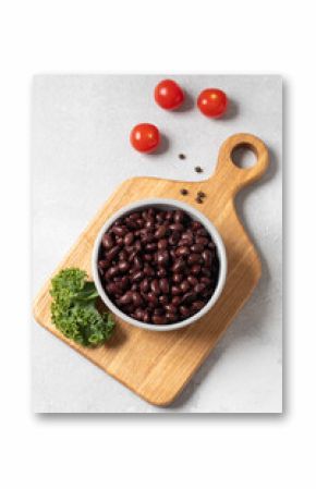 Black beans in a bowl on wooden cutting board with kale leaf
