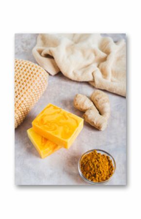 Herbal turmeric soap bars and root on the table vertical view