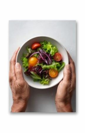 Senior woman holding a bowl of fresh mixed green salad with lettuce, tomatoes, onions, promoting healthy eating habits for active aging and overall well being
