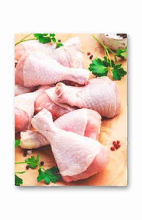 Raw chicken legs on parchment with pepper, salt and parsley. Top view