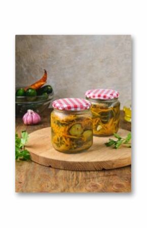 Pickled vegetable salad of cucumbers and carrots in glass jars on a wooden background. Canning, preparations. Step-by-step recipes.