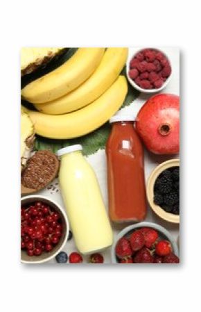 Superfood. Bottles with tasty smoothies and ingredients on light wooden table, flat lay