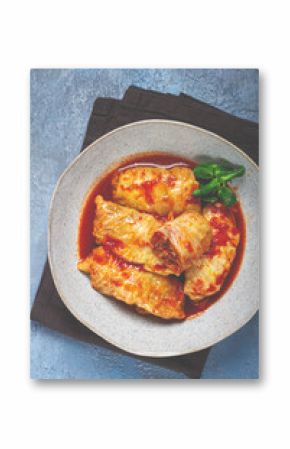 Stuffed cabbage rolls with minced meat, in tomato sauce, top view, without people, in the spotlight.