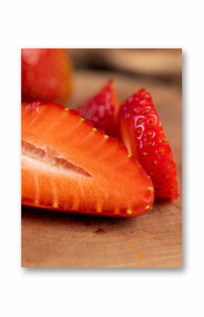 several sliced red ripe strawberries, ripe sweet and juicy strawberries cut into pieces on a wooden table