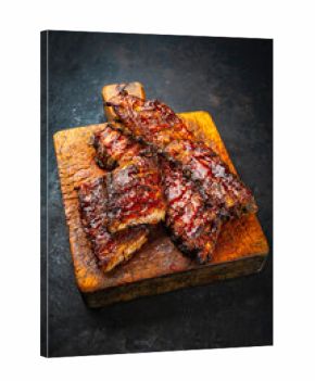 Barbecue smoked hot spicy pork spareribs St Louis cut with curry rub and BBQ sauce on wooden cutting board