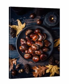 Organic sweet chestnuts with pumpkins on kitchen table, prepared for baking or cooking