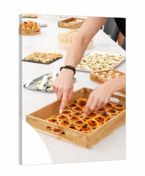 Buffet de fête avec plateau de tartelettes salées garnies d’olives noires, amuse-bouches variés servis lors d’un baptême, mariage ou réception familiale.