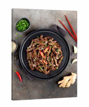 Asian teriyaki beef strips with spice, sesame on a gray background. Top view. Asian food.