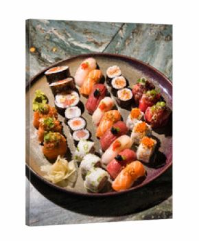 Colorful sushi platter with assorted nigiri, maki and gunkan featuring fresh salmon, tuna and seafood, artfully arranged for an authentic japanese dining experience