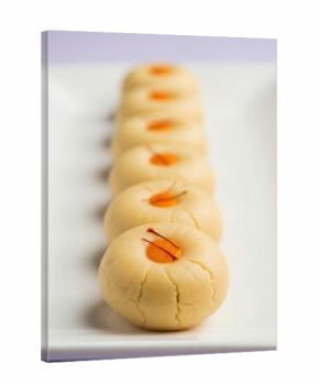 Peda sweets on white ceramic plate in studio with pastel lavender background, shallow depth of field and soft diffused lighting