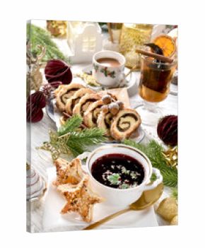 Christmas Eve table with traditional red borscht with star shaped puff pastry pies and cake